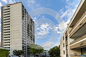 High multistoried apartment building with trees against blue sky