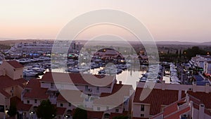 High perspective timelapse of sunset at Vilamoura Marina, Algarve, Portugal with busy nightlife around the Marina full