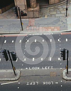 High perspective view of empty pedestrian crossing in the City of London. Iconic look left and look right signs painted