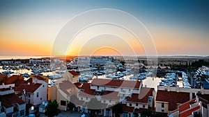 High perspective view of sunset at Vilamoura Marina, Algarve, Portugal with busy nightlife around the Marina full of