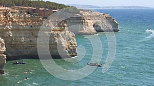 High perspective view of tourist boats entering the Algar de Benagil caves in Lagoa, Algarve, Portugal