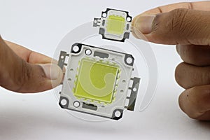 High power light emitting diode chips of various size held in the hand. smd led bead chips