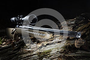 High powered scope on a hunting rifle in a dark forest