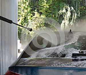 High-Pressure Car Wash on a Sunny Day Outside a Vehicle Service Center