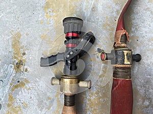 The high-pressure water gun and the firefighter`s hose coupling are placed on an outdoor concrete floor