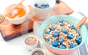 High protein healthy breakfast, buckwheat porridge with blueberries, flax seeds and honey