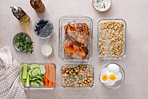 High protein healthy lunch meal prep in containers with chicken, quinoa, herbed chickpeas, vegetables and eggs