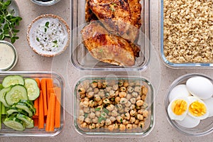 High protein healthy lunch meal prep in containers with chicken, quinoa, herbed chickpeas, vegetables and eggs