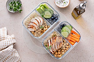 High protein healthy lunch meal prep in containers with chicken, quinoa, herbed chickpeas, vegetables and eggs