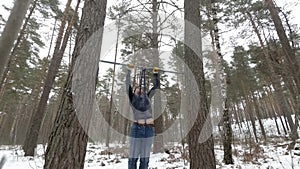 High pull ups. Young Athletic Man working out in forest