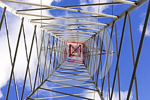 high pylon with high voltage cables for the transport of electricity and clouds on the sky