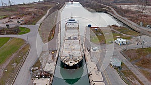 High quality, 4K aerial view of a bulk carrier ship maneuvering inside a canal