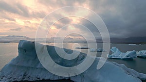A high quality 4K footage of the Glacier Lagoon Jokulsarlon in Iceland during the golden hour at colorful sunset lights
