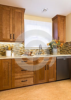 High quality contemporary home kitchen with wood cabinets, glass mosaic tile backsplash and recycled flooring