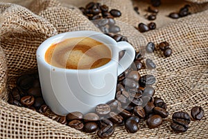 High quality espresso and coffee beans in burlap bag with espresso cup and spilling beans