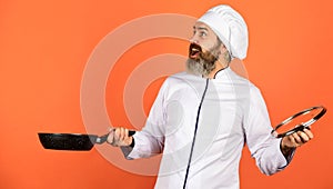 High quality frying pan. Bearded man cook white uniform. Cooking like pro. Regular cooking. Easy tasty meal prepared at