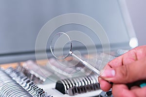 High quality photography. Close up of a hand accommodating a lens in a briefcase full of lenses with different prescriptions