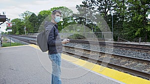 High quality picture of a young man who is waiting for a traing on a railway station. GO train station in Canada.