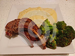High quality top and lamp chops cooked insert with mashed potatoes and steamed Italian broccoli
