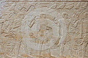 High Res well preserved painted ancient limestone Egyptian relief of human figures doing trade and hieroglyphs