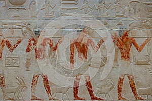 High Res well preserved painted ancient limestone Egyptian relief of human figures doing trades and hieroglyphs