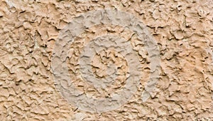 Rough beige plaster wall texture background with irregular stucco pattern.