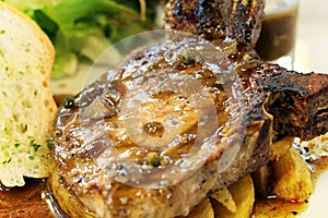 High resolution grilled `kuro buta`pork ribs and black pepper sauce served with potato wedges,bread and salad