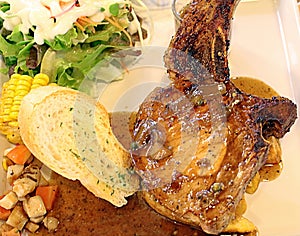 High resolution grilled `kuro buta`pork ribs and black pepper sauce served with potato wedges,bread and salad