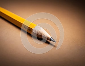 Sharp Yellow Pencil with Freshly Sharpened Tip on Smooth Surface
