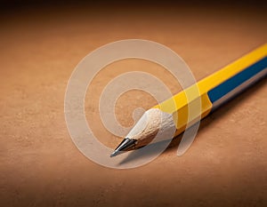 Sharp Yellow Pencil with Freshly Sharpened Tip on Smooth Surface