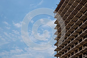 High-rise apartment building under construction against a blue sky with simple urban design