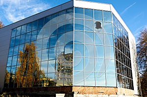 A high-rise building with a blue window smashed by vandals