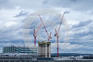 High rise building construction with red cranes over London.