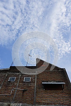 A high-rise building in a housing estate in a city with various types of architecture and a cloudy blue sky background. Perfect fo