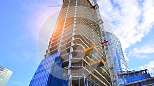 High rise building under construction. Installation of glass facade panels