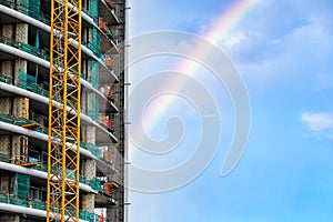 High-rise building under construction, with rainbow