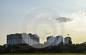 High-rise building under construction and tower cranes in the evening