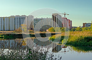 High-rise buildings under construction are reflected in the river