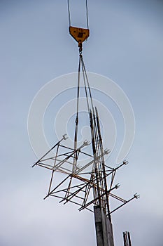 A high-rise construction crane lifts the lattice structure into the zone of building floor formation