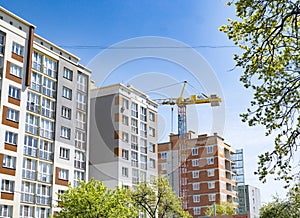 High-rise crane on the background of built houses