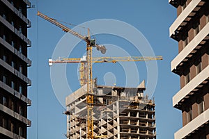 High-rise cranes are building a skyscraper. Civil real estate, construction site exterior