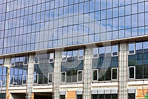 High-rise glass office building under construction with sky refl