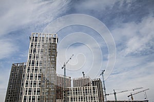 High-rise multi-storey buildings under construction. Tower cranes near building. Activity, architecture