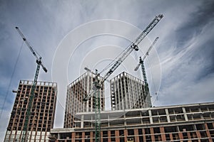 High-rise multi-storey buildings under construction. Tower cranes near building. Activity, architecture