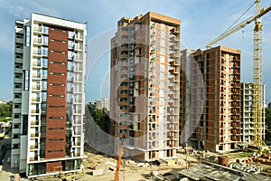 High-rise residential apartment buildings and tower crane under development on construction site. Real estate development