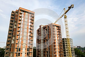 High-rise residential apartment buildings and tower crane under development on construction site. Real estate development