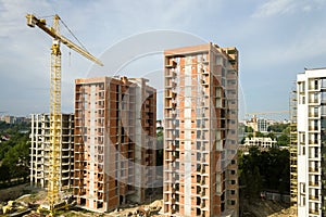 High-rise residential apartment buildings and tower crane under development on construction site. Real estate development