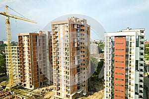 High-rise residential apartment buildings and tower crane under development on construction site. Real estate development