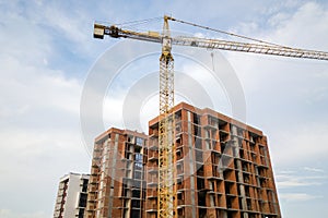 High-rise residential apartment buildings and tower crane under development on construction site. Real estate development