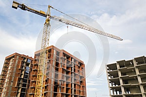 High-rise residential apartment buildings and tower crane under development on construction site. Real estate development